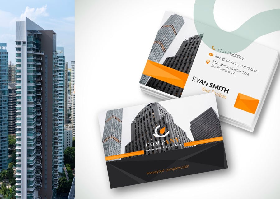 A stack of modern business cards with a sleek design, featuring high-rise buildings and bold orange accents. A tall cityscape is visible to the left.
